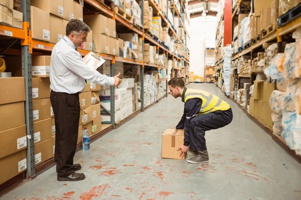 Manager20watching20worker20carrying20boxes20in20a20large20warehouse-2-3